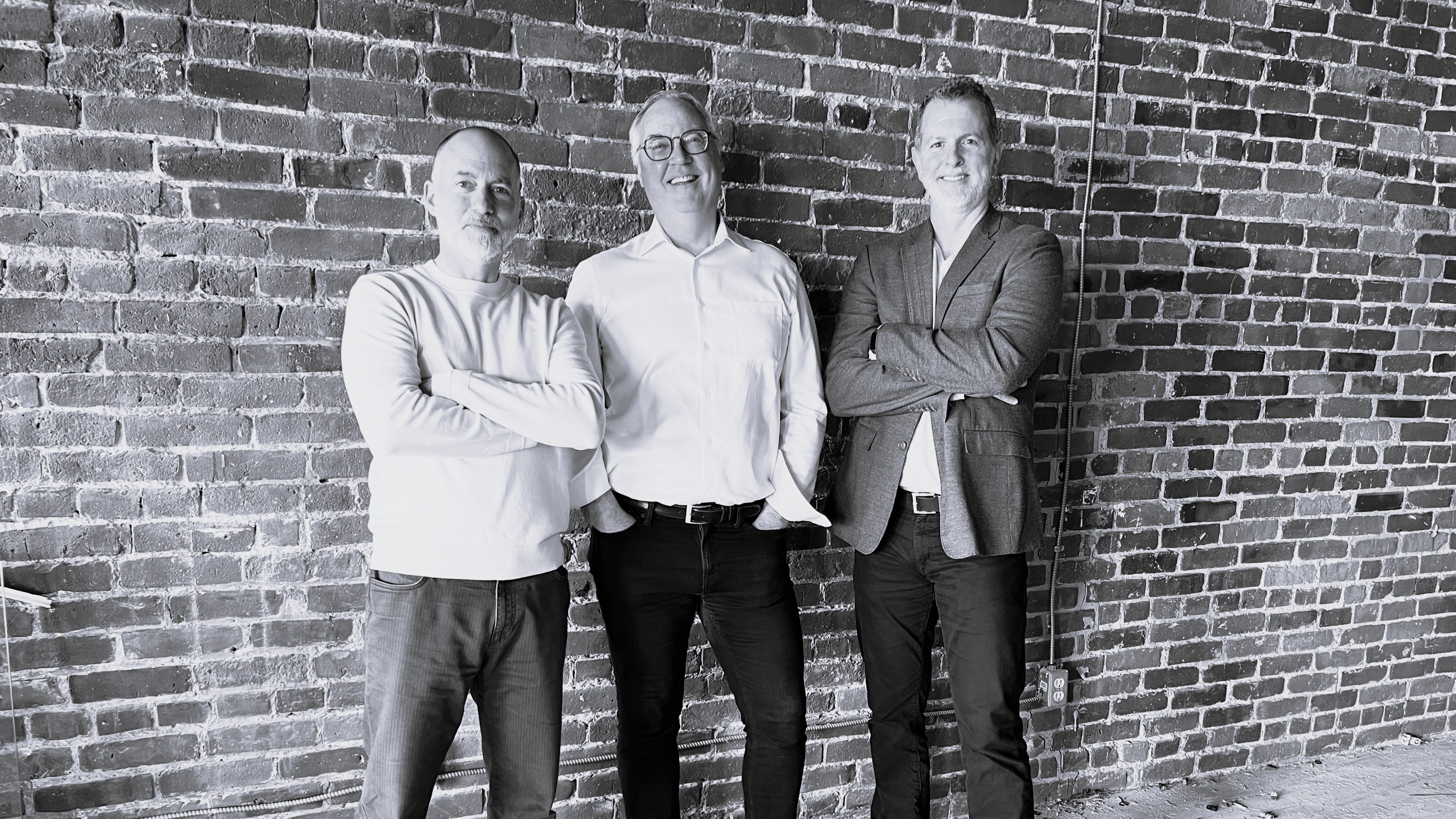 collabor8 leadership group portrait against a brick wall